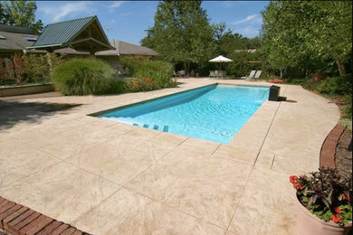 Design ideas for a large backyard rectangular lap pool in Chicago with a water feature and concrete pavers.