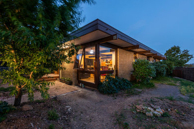 Idee per la villa piccola beige moderna a un piano con rivestimento in mattoni, tetto piano, copertura in metallo o lamiera e tetto marrone
