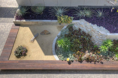 Ejemplo de jardín actual en patio con jardín francés, roca decorativa, exposición total al sol, entablado y con madera