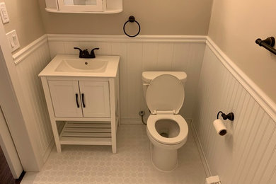 Example of a small farmhouse master white tile and ceramic tile ceramic tile and white floor bathroom design in New York with shaker cabinets, white cabinets, a two-piece toilet, beige walls, an integrated sink, quartz countertops and white countertops