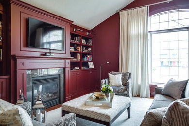 Inspiration for a transitional study room in Toronto with red walls, a standard fireplace, a wood fireplace surround and medium hardwood floors.