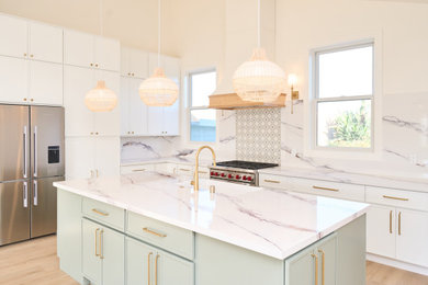Inspiration for a large laminate floor, beige floor and vaulted ceiling kitchen pantry remodel in Orange County with a farmhouse sink, shaker cabinets, white cabinets, quartz countertops, white backsplash, quartz backsplash, stainless steel appliances, an island and white countertops