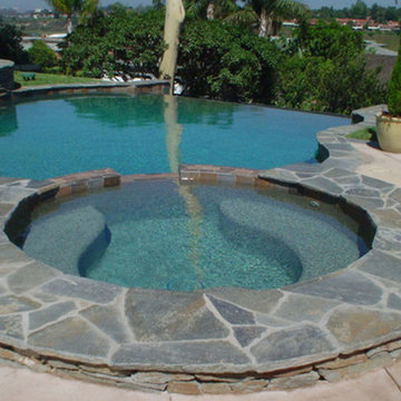 Red Mountain Stone Coping and Infinity Edge Pool | Swan Pools | Swimming Pool Co
