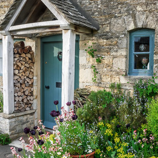 オックスフォードシャーの片開きドアカントリー風おしゃれな玄関ドア (青いドア、グレーの壁) の写真