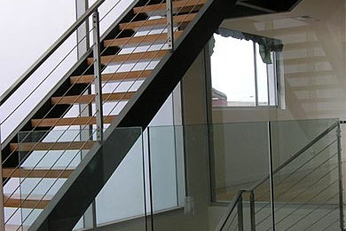 Large contemporary wood l-shaped staircase in Sydney with open risers.