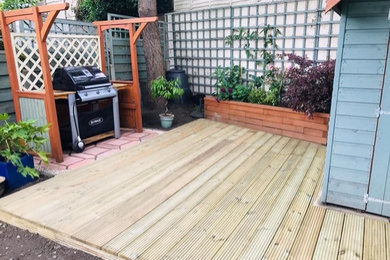 Inspiration for a medium sized traditional back formal partial sun garden for summer in London with decking.