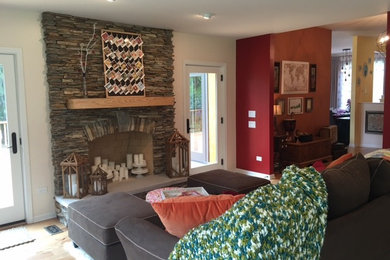Example of a mid-sized trendy formal and open concept medium tone wood floor and brown floor living room design in Chicago with multicolored walls, a hanging fireplace, a stone fireplace and no tv