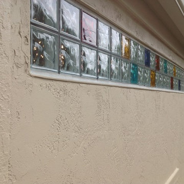 Exterior view of colored glass block transom in a stucco wall