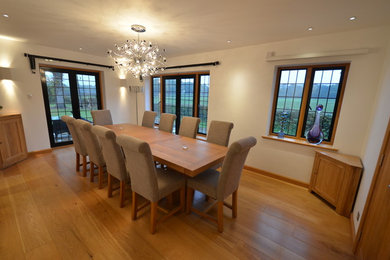 Inspiration for a large modern separate dining room in London with white walls, light hardwood floors and no fireplace.