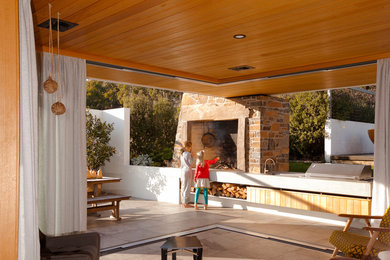 Inspiration for a courtyard patio in Hobart with a fire feature, tile and a roof extension.