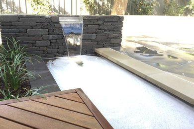 Photo of a contemporary courtyard partial sun garden for winter in Adelaide with with pond.