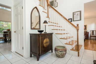 Traditional entryway in Boston with white walls, ceramic floors and white floor.