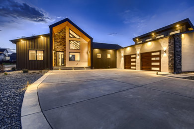 Large contemporary gray one-story stucco house exterior idea in Denver with a shed roof, a shingle roof and a black roof