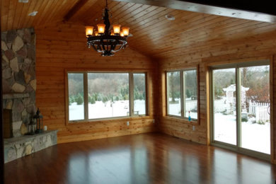 Living room - rustic living room idea in Other with a corner fireplace and a stone fireplace