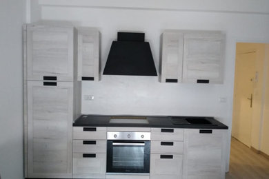 Источник вдохновения для домашнего уюта: прямая кухня-гостиная среднего размера в современном стиле с светлыми деревянными фасадами и белым полом