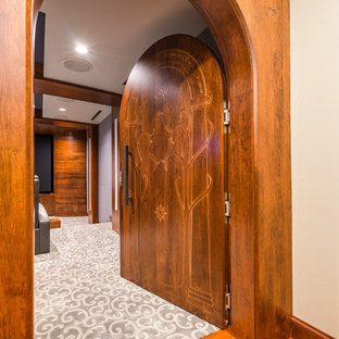 Réalisation d'une salle de cinéma design de taille moyenne et fermée avec un mur beige, un sol en bois foncé, un écran de projection et un sol marron.