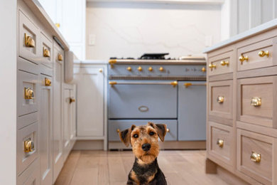 Enclosed kitchen - mid-sized french country u-shaped light wood floor, beige floor and exposed beam enclosed kitchen idea in DC Metro with a farmhouse sink, shaker cabinets, white cabinets, quartz countertops, white backsplash, quartz backsplash, white appliances, an island and white countertops