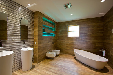 Freestanding bathtub - large modern master brown tile freestanding bathtub idea in Other with a pedestal sink and a wall-mount toilet