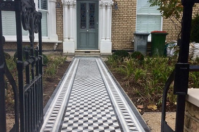 Photo of a large traditional front yard full sun driveway in London with a garden path.