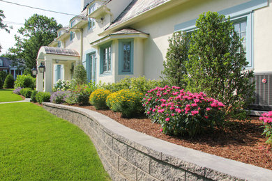 This is an example of a full sun front yard retaining wall landscape in New York.