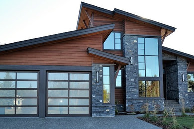 This is an example of a large contemporary two-storey brown house exterior in Calgary with mixed siding and a shed roof.