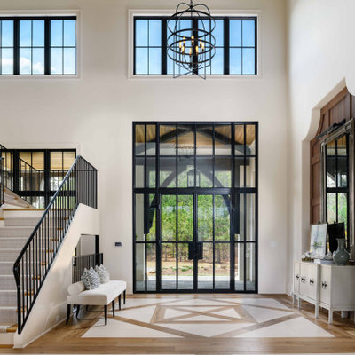 Inspiration for a huge transitional light wood floor, brown floor and wall paneling entryway remodel in Atlanta with white walls and a black front door
