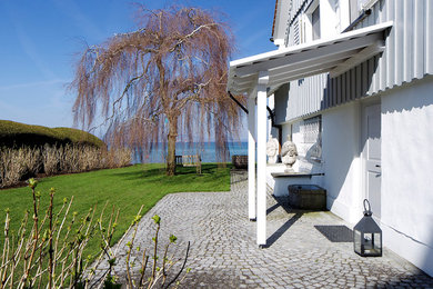 Mittelgroßer Maritimer Hanggarten im Frühling mit direkter Sonneneinstrahlung und Natursteinplatten in Sonstige