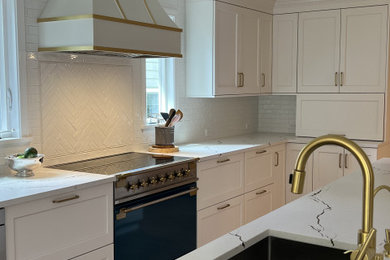 Example of a transitional light wood floor kitchen design in Seattle with an undermount sink, shaker cabinets, white cabinets, quartz countertops, porcelain backsplash, colored appliances and an island