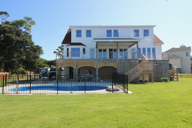 Inspiration for a large coastal white two-story vinyl exterior home remodel in Other with a shingle roof