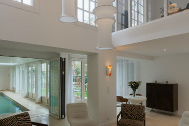 Idées déco pour un grand salon blanc et bois contemporain ouvert avec un mur blanc, un sol en travertin, une cheminée standard, un manteau de cheminée en plâtre, aucun téléviseur, un sol beige et un plafond cathédrale.