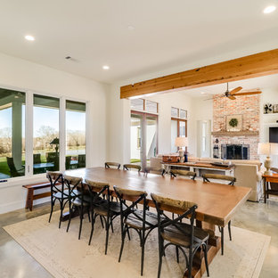 ジャクソンの広いカントリー風 LDKの画像 (白い壁、コンクリートの床、標準型暖炉、レンガの暖炉まわり、グレーの床)