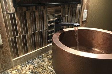 Alcove bathtub - mid-sized rustic brown tile and porcelain tile porcelain tile alcove bathtub idea in Other with beaded inset cabinets, medium tone wood cabinets, a two-piece toilet, brown walls, a vessel sink and granite countertops