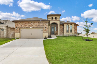 Inspiration for a mid-sized transitional brown two-story stone house exterior remodel in Austin with a hip roof and a shingle roof