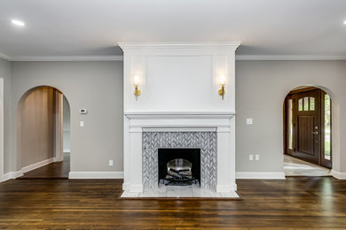 Inspiration for a mid-sized timeless dark wood floor and brown floor living room remodel in Wichita with gray walls, a standard fireplace and a tile fireplace
