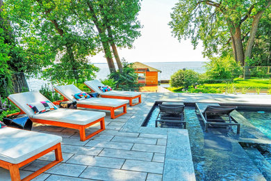 Example of a mid-sized trendy backyard stone and custom-shaped pool landscaping design in Montreal