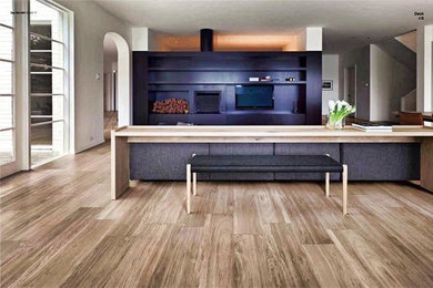 Example of a large minimalist open concept medium tone wood floor and brown floor living room design in Miami with white walls, a standard fireplace, a wood fireplace surround and a media wall