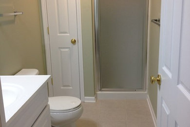 他の地域にある中くらいなトラディショナルスタイルのおしゃれなバスルーム (浴槽なし) (オーバーカウンターシンク、レイズドパネル扉のキャビネット、白いキャビネット、アルコーブ型シャワー、一体型トイレ	、ベージュの壁、セラミックタイルの床) の写真