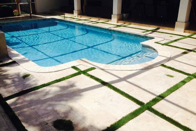 Large transitional backyard custom-shaped lap pool in Miami with stamped concrete.
