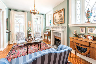 Inspiration for a large timeless formal and enclosed medium tone wood floor and brown floor living room remodel in Richmond with a standard fireplace, green walls, a stone fireplace and no tv