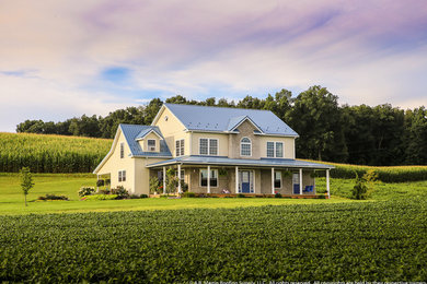 Imagen de fachada de casa beige clásica de tamaño medio de dos plantas con revestimiento de vinilo, tejado a dos aguas y tejado de metal