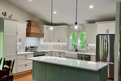 Example of a mid-sized country l-shaped light wood floor and brown floor open concept kitchen design in Detroit with a farmhouse sink, shaker cabinets, white cabinets, quartz countertops, multicolored backsplash, ceramic backsplash, stainless steel appliances, an island and white countertops