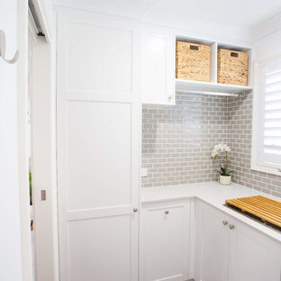 Foto de cuarto de lavado en L, tradicional, pequeño, con fregadero de un seno, armarios estilo shaker, puertas de armario blancas, encimera de cuarzo compacto, paredes blancas, suelo de baldosas de porcelana, suelo gris y encimeras blancas