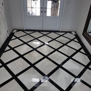 両開きドアモダンスタイルのおしゃれな玄関ラウンジ (白い壁、御影石の床、白いドア) の写真