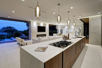 Expansive modern single-wall open plan kitchen in Los Angeles with an undermount sink, flat-panel cabinets, medium wood cabinets, quartz benchtops, stainless steel appliances, concrete floors, with island, grey floor and white benchtop.