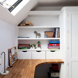 Design ideas for a mid-sized contemporary study room in Kent with white walls, a built-in desk, carpet, a standard fireplace, a tile fireplace surround and beige floor.