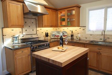 Transitional u-shaped brown floor kitchen photo in San Francisco with an undermount sink, raised-panel cabinets, medium tone wood cabinets, beige backsplash, matchstick tile backsplash, stainless steel appliances and an island