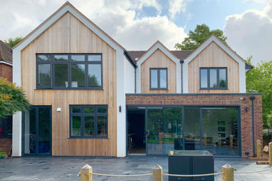 Diseño de fachada contemporánea de dos plantas con revestimiento de madera y panel y listón