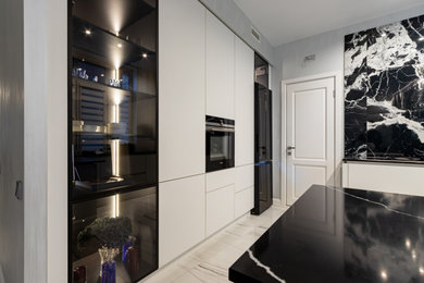 Источник вдохновения для домашнего уюта: прямая кухня среднего размера: освещение в современном стиле с плоскими фасадами, белыми фасадами и обеденным столом