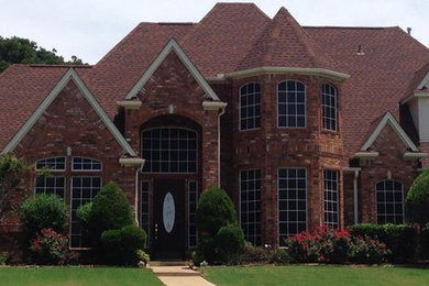 Example of a large red three-story brick gable roof design in Dallas