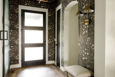 Mid-sized transitional medium tone wood floor and wallpaper entryway photo in Boise with a black front door
